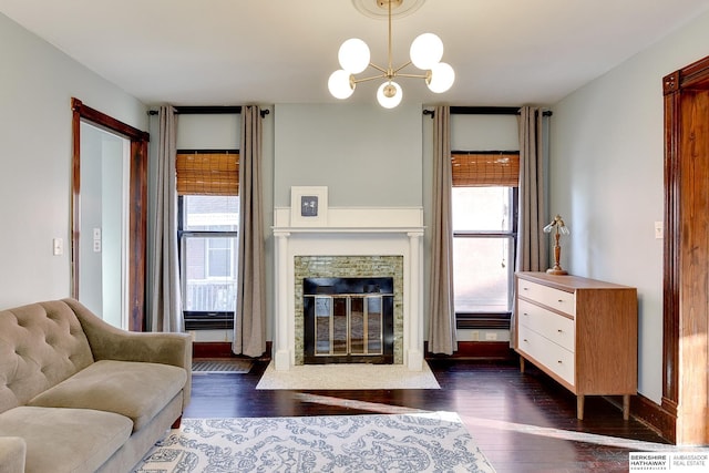 living room with dark wood-style floors, a stone fireplace, and a healthy amount of sunlight