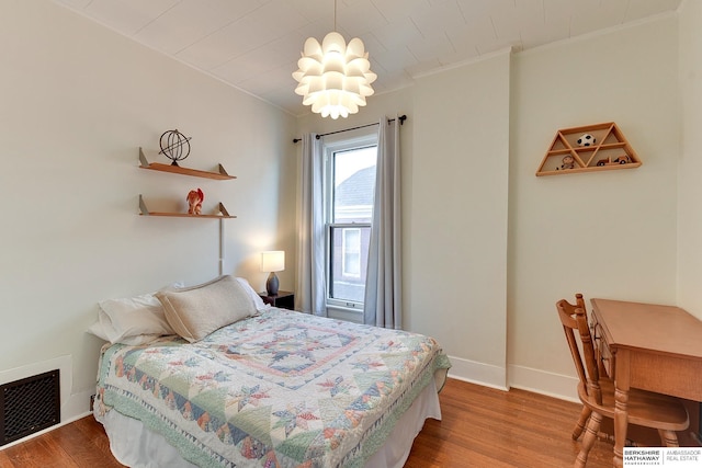 bedroom featuring wood finished floors, visible vents, and baseboards