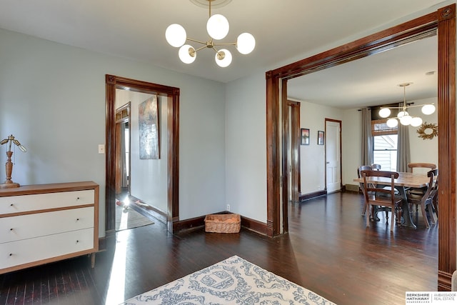 interior space with baseboards, wood finished floors, and a chandelier