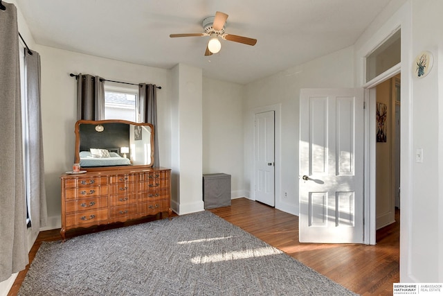 bedroom with a ceiling fan, wood finished floors, and baseboards