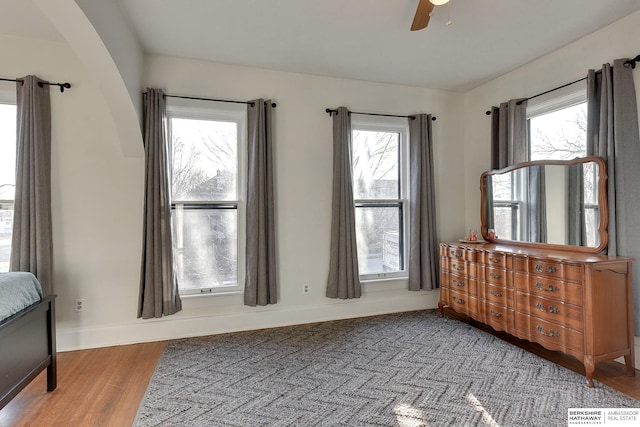 bedroom featuring visible vents, a ceiling fan, baseboards, and wood finished floors