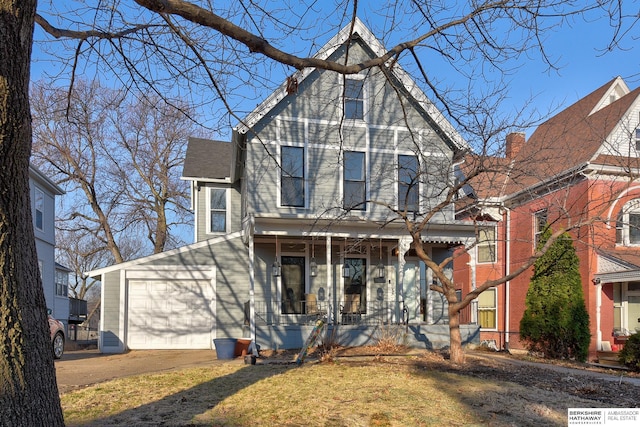 view of front of house featuring a porch, concrete driveway, and an attached garage