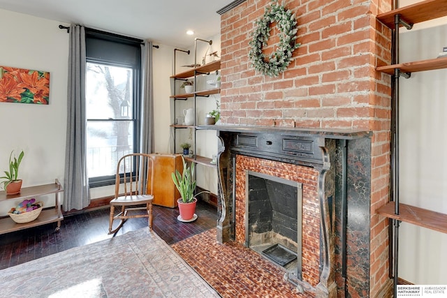 living room featuring plenty of natural light, a brick fireplace, baseboards, and hardwood / wood-style floors