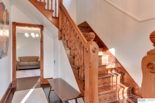 stairs with a high ceiling, baseboards, and wood finished floors