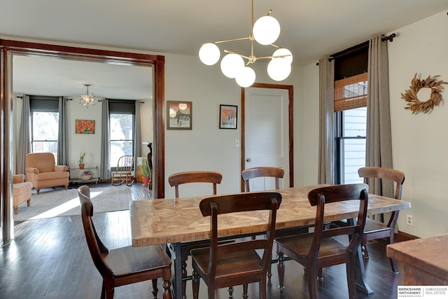 dining space featuring a notable chandelier, baseboards, and dark wood-type flooring