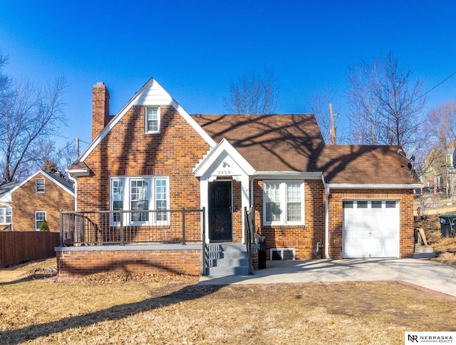 view of front facade featuring brick siding, driveway, a chimney, and a garage