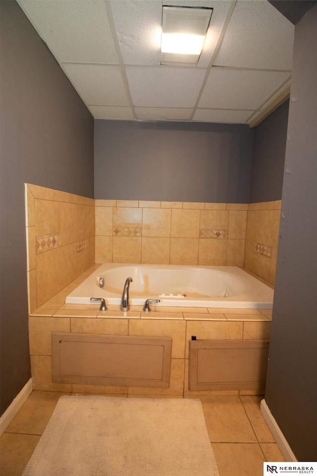 bathroom featuring tile patterned flooring, a paneled ceiling, baseboards, and a whirlpool tub