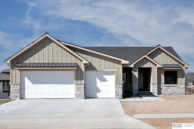 view of front of property with board and batten siding, an attached garage, a standing seam roof, and concrete driveway