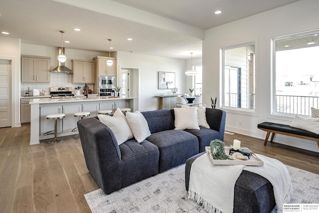 living room featuring recessed lighting, light wood-type flooring, and baseboards