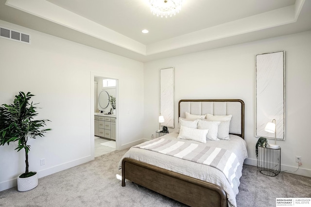 bedroom with visible vents, light colored carpet, a raised ceiling, and baseboards