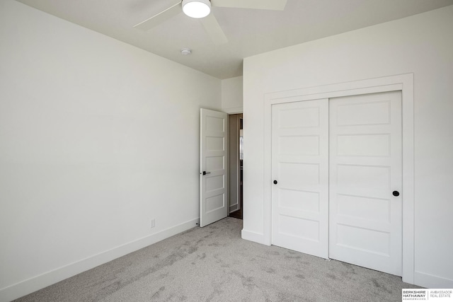 unfurnished bedroom featuring a closet, light colored carpet, a ceiling fan, and baseboards