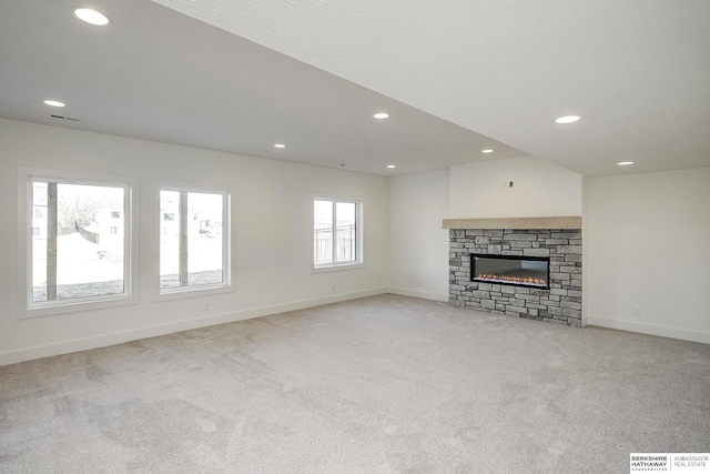 unfurnished living room with visible vents, light carpet, recessed lighting, a fireplace, and baseboards