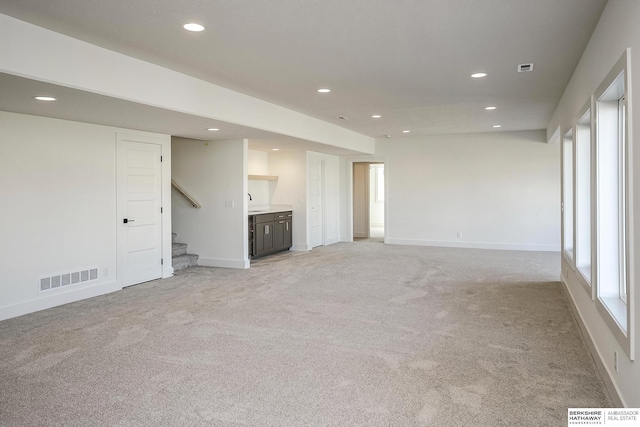 unfurnished living room featuring baseboards, recessed lighting, visible vents, and light carpet