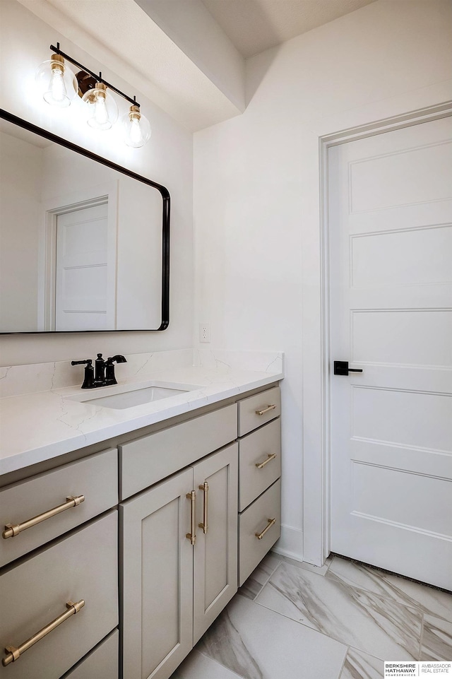 bathroom with marble finish floor and vanity