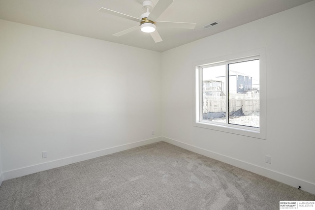 carpeted empty room featuring visible vents, a ceiling fan, and baseboards