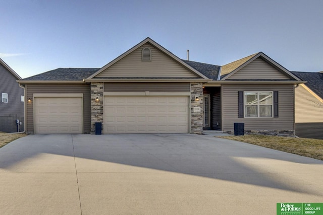 ranch-style home with stone siding, an attached garage, and driveway