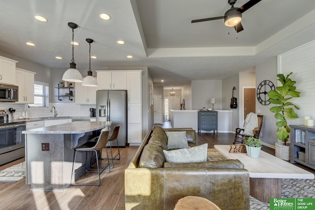 living area featuring baseboards, recessed lighting, dark wood-style flooring, and ceiling fan