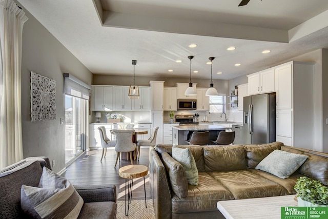 living area with a ceiling fan, recessed lighting, and wood finished floors