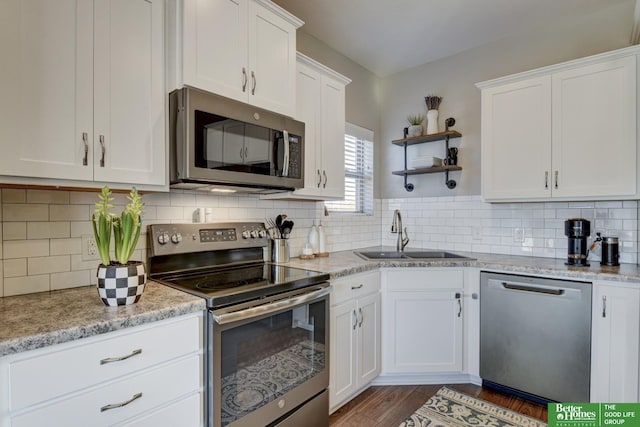 kitchen with tasteful backsplash, a sink, stainless steel appliances, white cabinetry, and open shelves