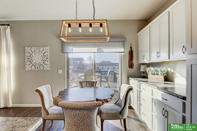 dining area with baseboards and wood finished floors