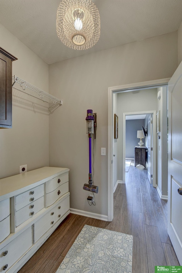 washroom featuring laundry area, wood finished floors, baseboards, and hookup for an electric dryer