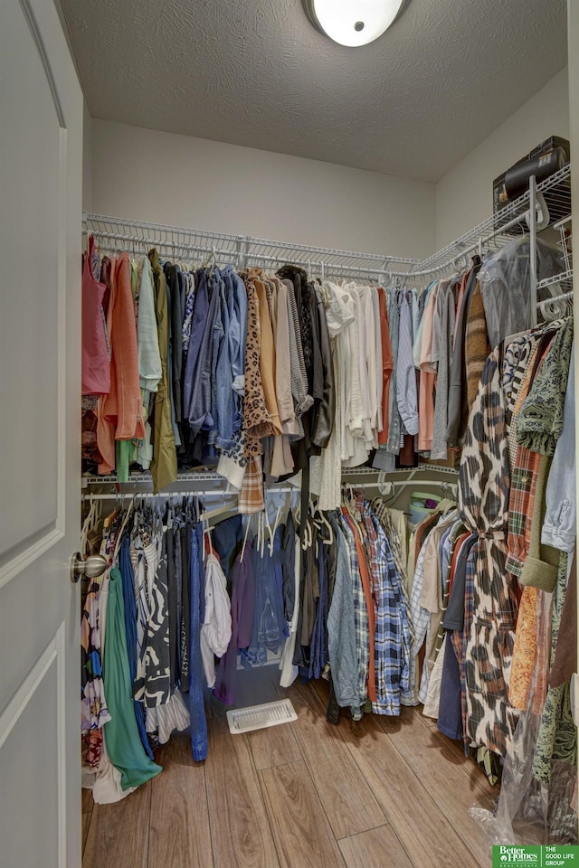 spacious closet featuring wood finished floors and visible vents