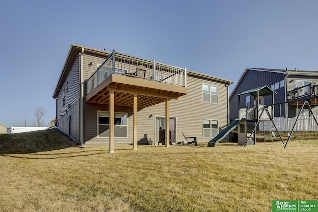 back of property with a deck, a playground, and a yard