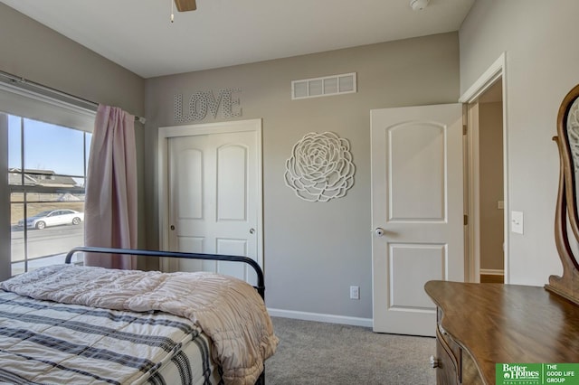 carpeted bedroom with a closet, visible vents, and baseboards