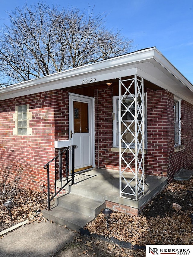 entrance to property featuring brick siding