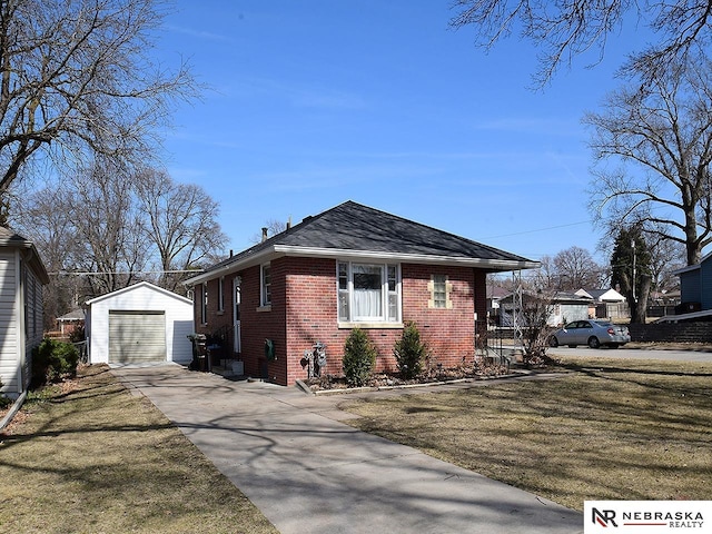 view of home's exterior featuring brick siding, an outdoor structure, driveway, and a lawn