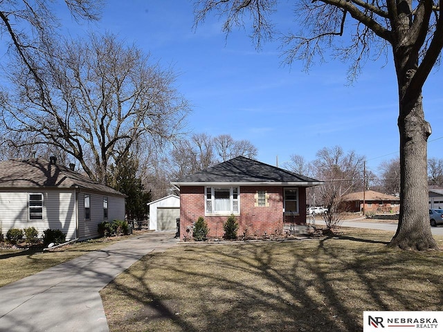 view of front facade with an outdoor structure, a garage, brick siding, and a front yard