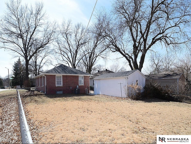 exterior space featuring brick siding, cooling unit, and an outdoor structure