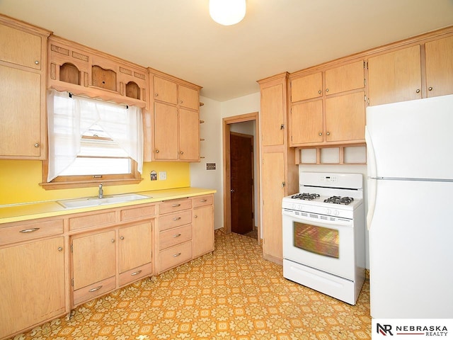 kitchen with white appliances, light floors, a sink, light brown cabinetry, and light countertops