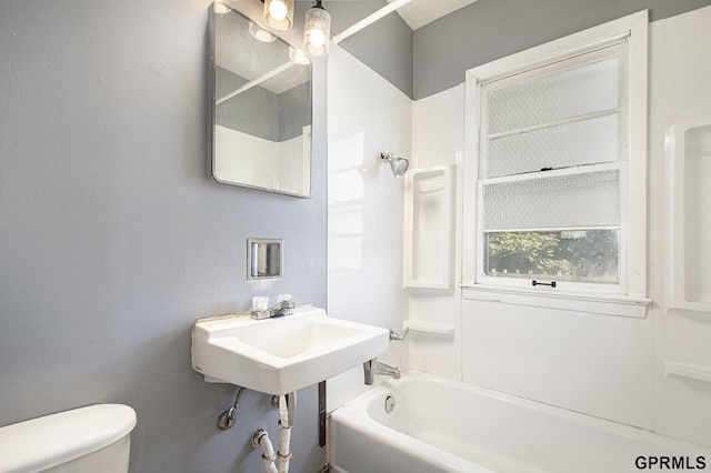 full bath featuring toilet,  shower combination, and a sink