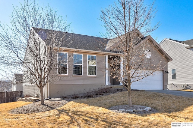 view of front of house featuring fence, roof with shingles, concrete driveway, a front yard, and an attached garage