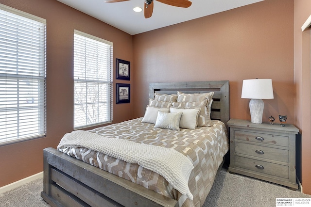 bedroom with baseboards, multiple windows, and carpet