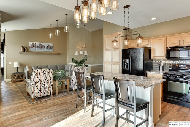 kitchen with light wood-style flooring, black appliances, a chandelier, and light brown cabinets