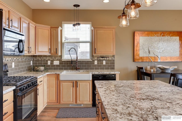 kitchen with black appliances, light brown cabinets, a sink, decorative backsplash, and light stone countertops