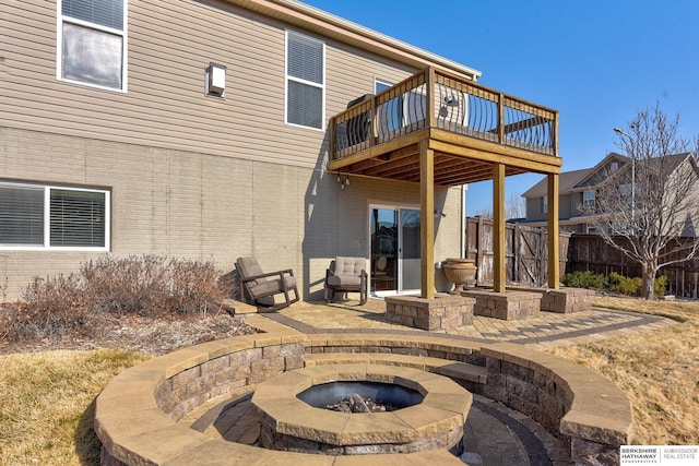 view of patio / terrace with a wooden deck, fence, and an outdoor fire pit