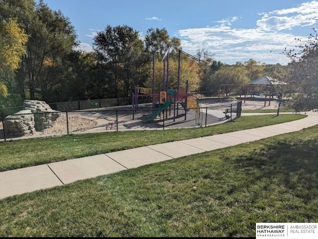 community jungle gym with a lawn and fence