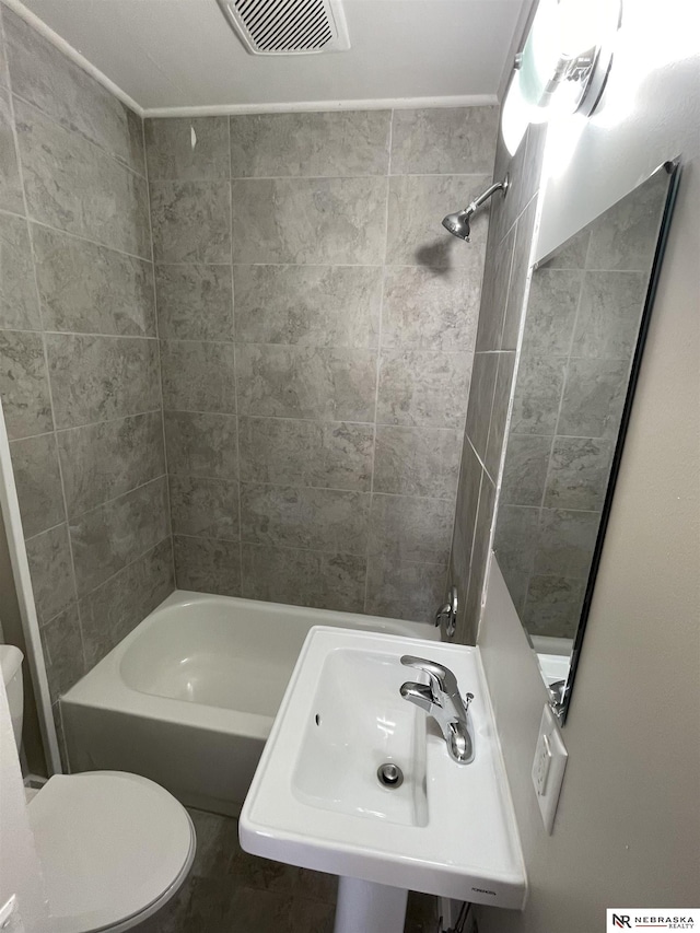 full bathroom featuring  shower combination, toilet, visible vents, and a sink