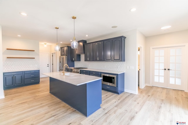 kitchen featuring light wood-style flooring, open shelves, appliances with stainless steel finishes, light countertops, and decorative backsplash