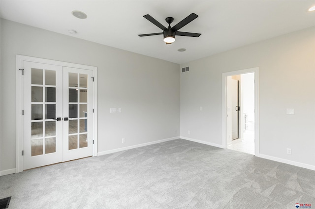 empty room featuring a ceiling fan, carpet flooring, french doors, and visible vents