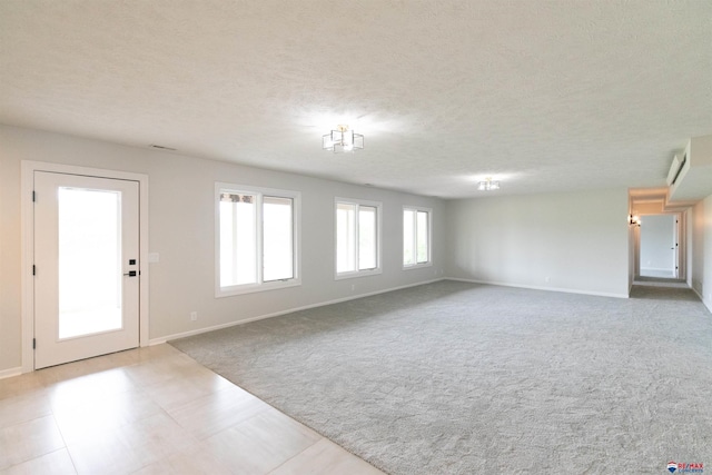 interior space with carpet, baseboards, and a textured ceiling