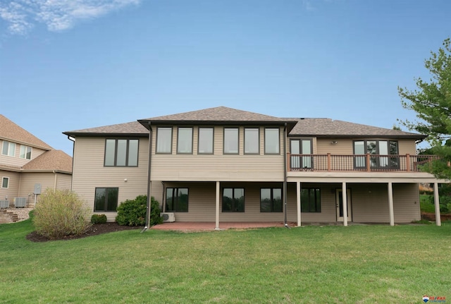 back of house with a lawn, roof with shingles, central AC, and a patio area