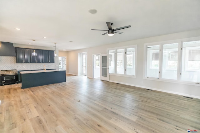 unfurnished living room featuring light wood-style flooring, baseboards, visible vents, and ceiling fan