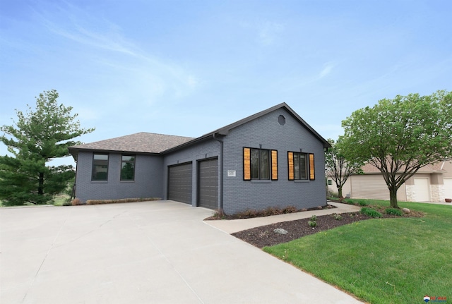 view of front of property featuring brick siding, driveway, a front yard, and a garage