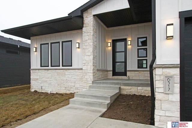 entrance to property with board and batten siding and stone siding