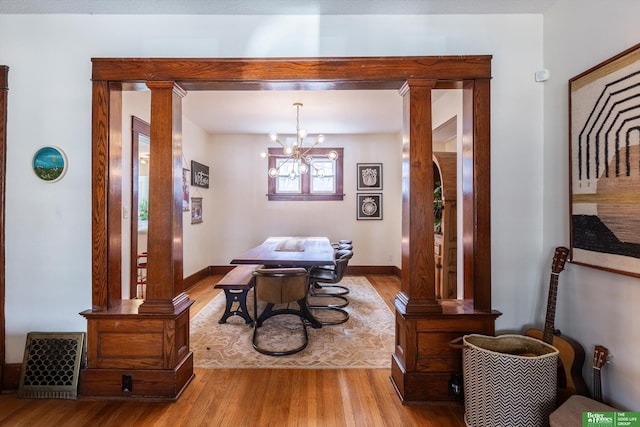 dining space featuring a notable chandelier, baseboards, and wood finished floors