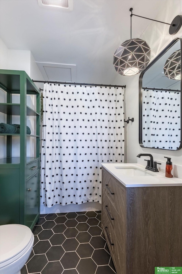 bathroom with vanity, a shower with curtain, visible vents, tile patterned floors, and toilet